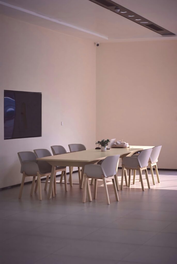 A bright, spacious dining area featuring minimalist decor, a table, chairs, and a wall-mounted TV, perfect for contemporary homes.